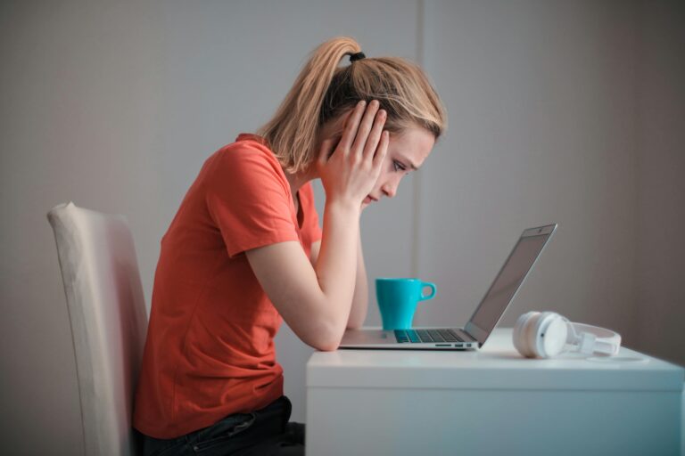 Rescisão indireta: Mulher preocupada olhando para o laptop.